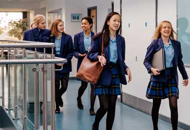 Alumnas de uniforme paseando por el pasillo del Colegio